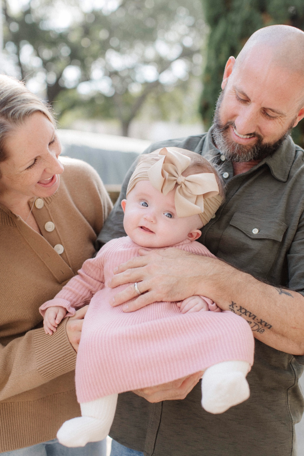 Parents holding baby Harlow outdoors
